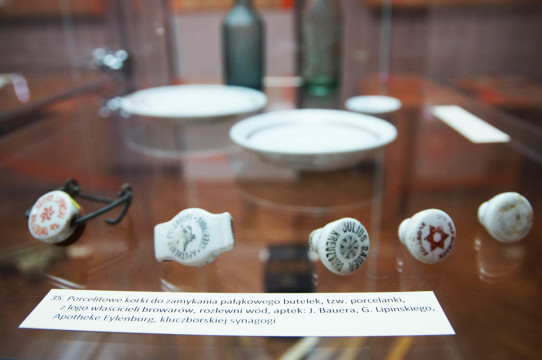 Fragment ekspozycji - na fotografii widoczna gablota,w której znajdują się porcelitowe korki do zamykania butelek.