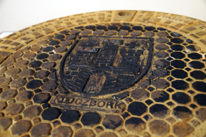 Nietypowy stempel - właz studzienki kanałowej z herbem Kluczborka